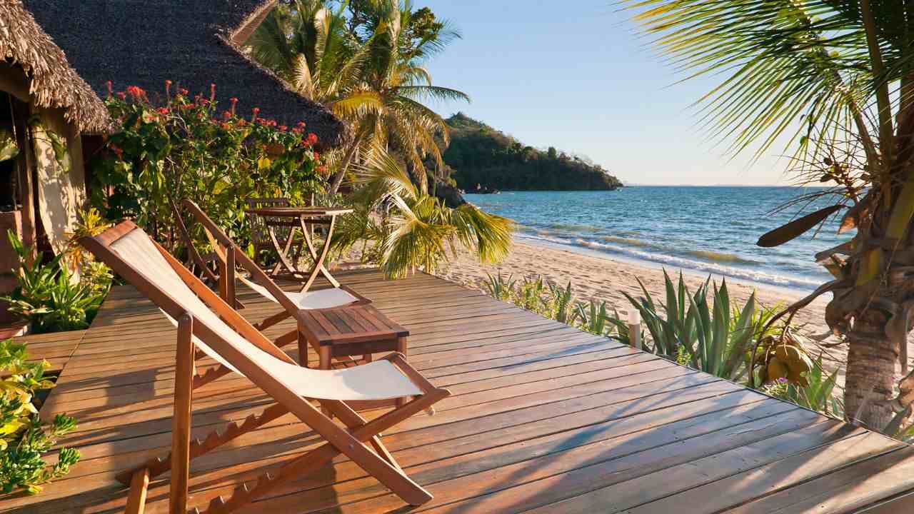 Casa moderna no litoral de Ubatuba vista do alto, mar azul e natureza ao redor — inspiração para quem sonha em comprar casa na praia.